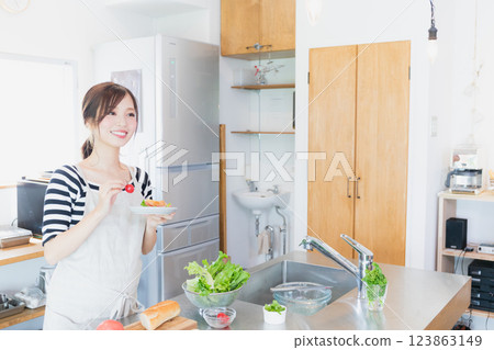 一個圍裙，在廚房裡做飯的女人 123863149