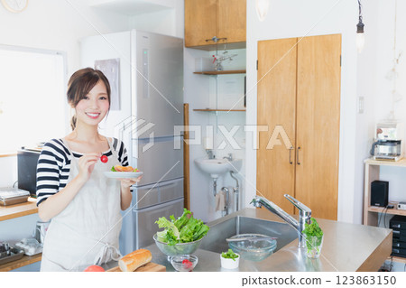 一個圍裙，在廚房裡做飯的女人 123863150