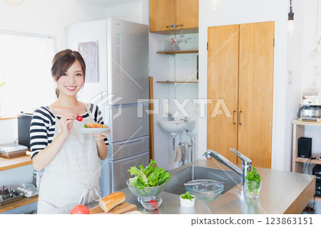 一個圍裙，在廚房裡做飯的女人 123863151