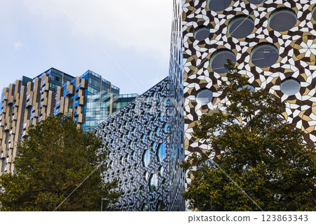Modern architectural building with unique geometric facade and reflective windows Modern architectural building with unique geometric facade and reflective windows 123863343