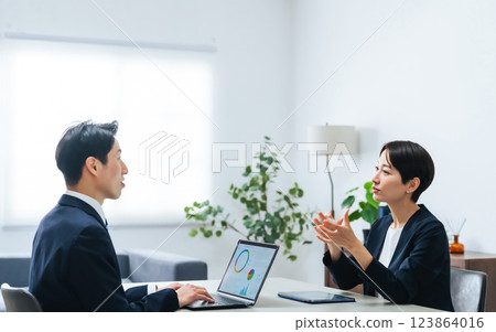 A group of male and female business people having a meeting in an office A group of male and female business people having a meeting in an office 123864016