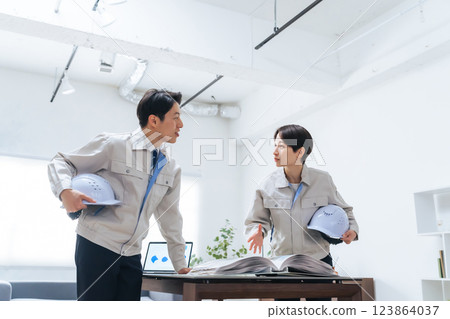 一群工人一邊看手冊一邊討論 123864037