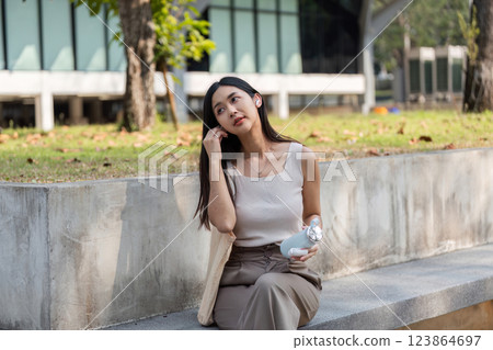 Sustainable lifestyle. Young woman enjoying a reusable cup while sitting outdoors. Sustainable lifestyle. Young woman enjoying a reusable cup while sitting outdoors. 123864697