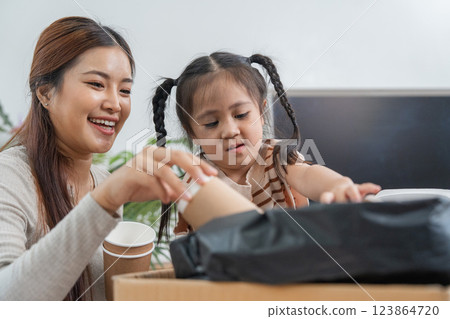 Recycling Fun and Learning. A mother and daughter happily sorting recyclable materials together. 123864720
