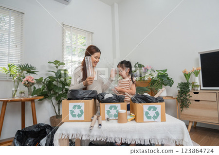 Home Recycling and Education. A mother and daughter actively sorting recyclables in their eco-friendly home. 123864724