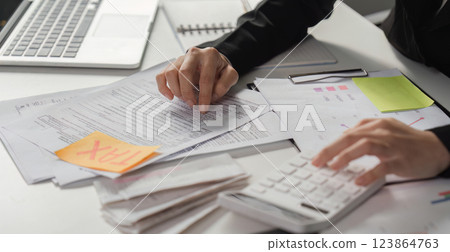 Tax preparation and analysis. Business professional reviewing tax documents and financial statements in the office. Tax preparation and analysis. Business professional reviewing tax documents and financial statements in the office. 123864763