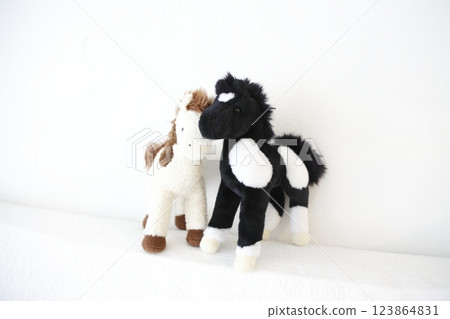 A pair of stuffed horses photographed against a white background A pair of stuffed horses photographed against a white background 123864831