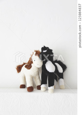 A pair of stuffed horses photographed against a white background A pair of stuffed horses photographed against a white background 123864837