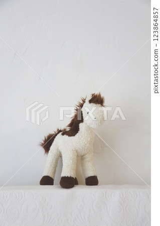 Beige and brown stuffed horse doll photographed against a white background Beige and brown stuffed horse doll photographed against a white background 123864857