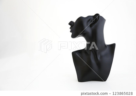 A black object around a person's neck photographed against a white background A black object around a person's neck photographed against a white background 123865028