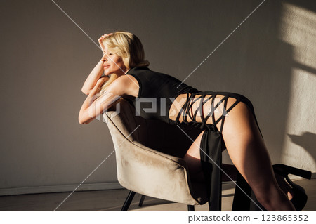 slim blonde woman in black evening dress 123865352
