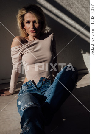 Beautiful fashion blonde woman in jeans by the window 123865357