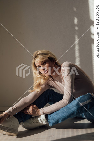 Beautiful fashion blonde woman in jeans by the window 123865358