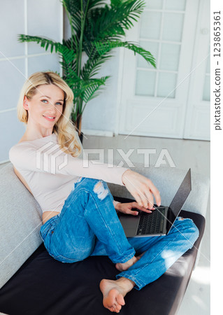 Blonde woman working on laptop learning from home online 123865361