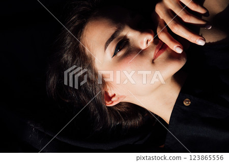 Beautiful slender woman in black lingerie lying on bed 123865556