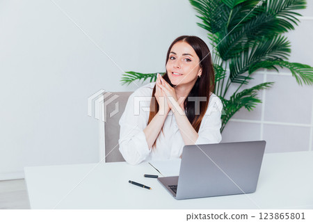 woman working at desk on laptop online learning in office 123865801
