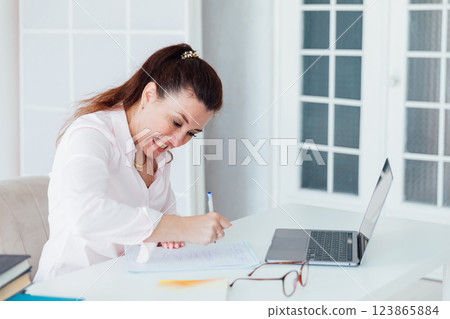 woman at desk with laptop nervous writing online 123865884