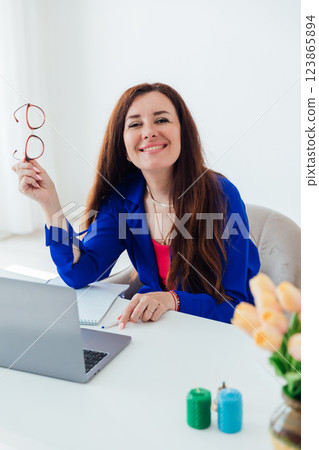 woman smiling at laptop studying in office online woman smiling at laptop studying in office online 123865894