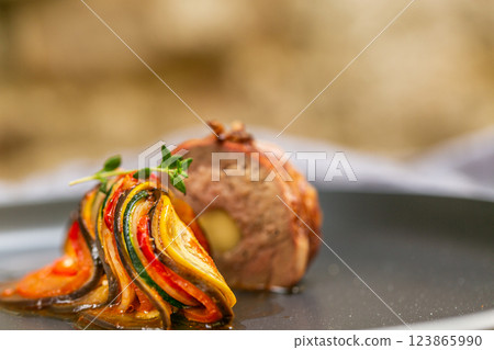 Chef preparing traditional Provencal vegetable dish Ratatouille with stuffed rolled meat on the grill. French food. Healthy eating 123865990