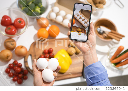 The hands of a middle-aged woman taking pictures of cooking ingredients with her smartphone 123866041
