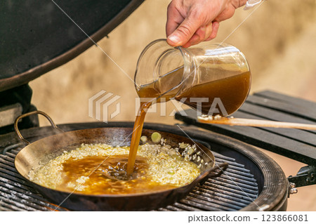 The chef prepares a traditional seafood paella on the grill. Traditional spanish dish. 123866081
