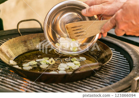 The chef prepares a traditional seafood paella on the grill. Traditional spanish dish. The chef prepares a traditional seafood paella on the grill. Traditional spanish dish. 123866094