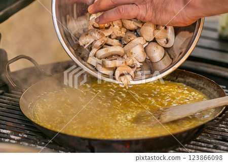 The chef prepares a traditional seafood paella on the grill. Traditional spanish dish. The chef prepares a traditional seafood paella on the grill. Traditional spanish dish. 123866098