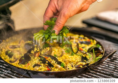 The chef prepares a traditional seafood paella on the grill. Traditional spanish dish. 123866109