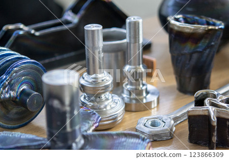 Objects printed with a 3D printer from a filament of molten metal on a table. 123866309