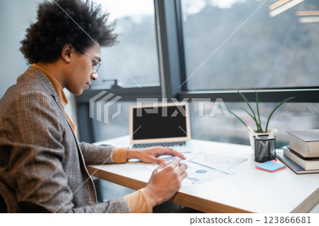 Curly-haired young businessman working on the project in the office 123866681