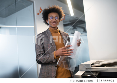 Young man putting the documents in the file and looking involved 123866693