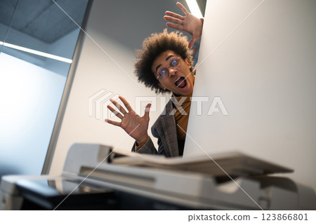 Waist up of a astonished young man near the xerox machine Waist up of a astonished young man near the xerox machine 123866801