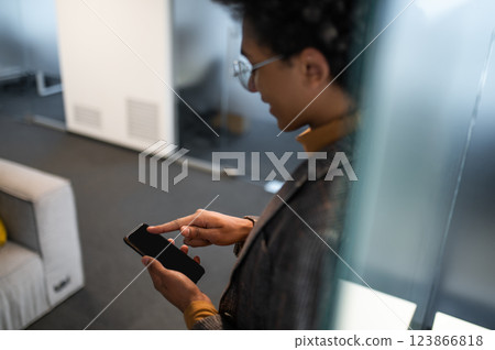 Good-looking young man wit a phone in hands in the office 123866818