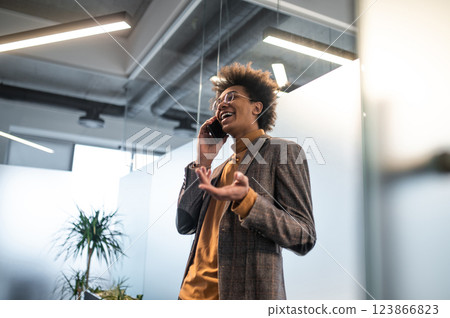 Good-looking young man wit a phone in hands in the office Good-looking young man wit a phone in hands in the office 123866823