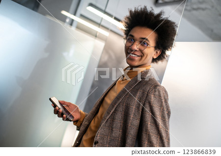 Confident curly-haired young businessman in the office Confident curly-haired young businessman in the office 123866839