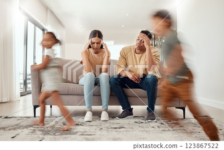 Headache, noise and stress with family in living room and parents overwhelmed by adhd kids energy. Tired, burnout and man, woman and hyper active children running in house, having fun or playing game 123867522