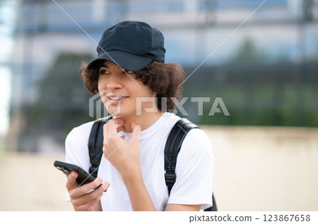 Teenager sitting on the blocks and communicating in the phone Teenager sitting on the blocks and communicating in the phone 123867658