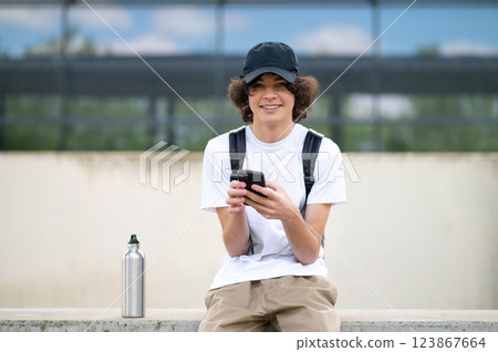 Dark-haired teenager sitting on the blocks and resting after classes 123867664