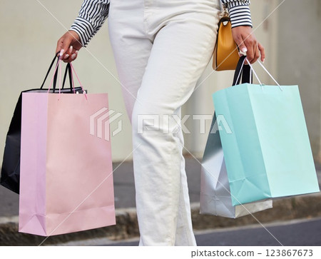 Hands, bags and shopping with a woman customer walking on a city street at an outdoor mall or boutique. Store, retail and sale with a female shopper in town on the search for a discount or deal 123867673