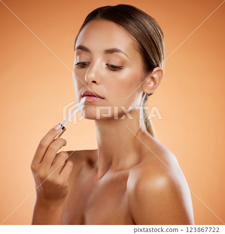 Woman beauty, liquid lipstick and makeup, cosmetics and luxury skincare product on studio background. Aesthetic, beautiful young model headshot applying lip gloss to mouth, shine and grooming glamour 123867722