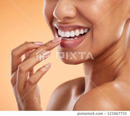 Woman, lips and smile with teeth for cosmetics, makeup and hand for treatment against a studio background. Closeup of female beauty for mouth care, happy smile in satisfaction for oral skincare Woman, lips and smile with teeth for cosmetics, makeup and hand for treatment against a studio background. Closeup of female beauty for mouth care, happy smile in satisfaction for oral skincare 123867735