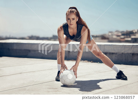 Soccer, fitness and woman training in the city with a ball for cardio, health and body goal. Portrait of a strong, stretching and healthy athlete with a football for her workout and sports exercise 123868057