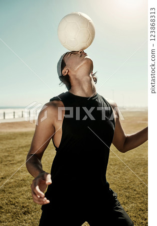Head balance, soccer and sports man in nature with a sport ball busy with football training. Fitness, workout and health exercise of a strong person on a field by the beach exercising for a game 123868313