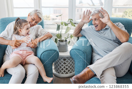 Happy, grandfather and grandmother with child, excited and bonding being silly, goofy or funny in living room at home. Elderly man, senior woman or grandchild being playful, connect or laugh together Happy, grandfather and grandmother with child, excited and bonding being silly, goofy or funny in living room at home. Elderly man, senior woman or grandchild being playful, connect or laugh together 123868355