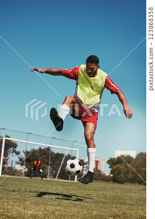 Sport, fitness and soccer training with soccer player in soccer ball power kick on a soccer field, energy, exercise and passion. Sports, football and football player ball practice on football field 123868358