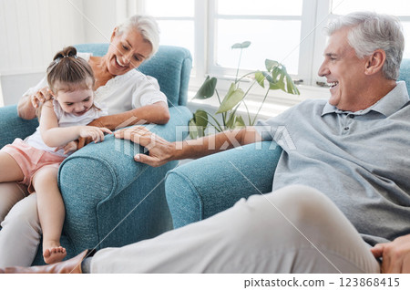 Happy family, love and grandparents with child relax, bond and enjoy fun quality time together on home living room sofa. Young kid, senior grandfather smile and elderly grandma play with youth girl 123868415