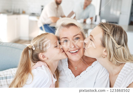 Grandma, family and child giving a kiss on cheek and senior woman with smile sitting with mother and child on sofa at home. Portrait of happy grandparent bonding with girl and daughter on mothers day 123868502