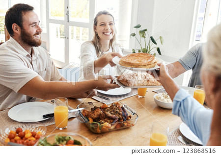 Big family, lunch and food in home dining room with people sharing a meal. Love, happy and relatives eating food, bread and delicious gourmet chicken on table while spending quality time together. 123868516