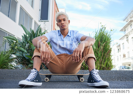 Skateboard, gen z and cool skater man in the city with a serious look outdoor. Portrait of a urban person from Mexico relax after skate training, fitness and cardio workout practice on the road 123868675