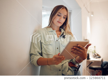 Woman, small business and research on tablet for startup company browsing internet in remote work at salon. Professional freelancer female on touchscreen for online marketing or social media at home 123868711